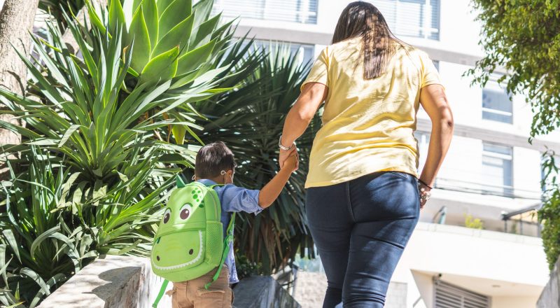Mother and her son with their backs turned to school